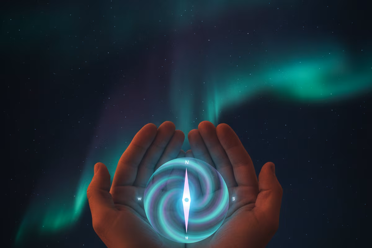 A glowing aurora compass held in cupped hands under a starry northern sky